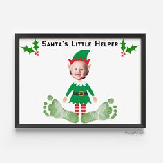 a framed christmas card with an image of a baby elf on it's feet