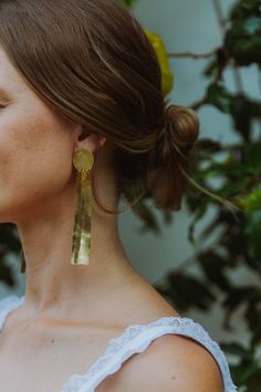 "Lightweight and hand-hammered, dangling earrings. Chic and statement-making. Made by Helena Aguilar in Medellín, Colombia. Size: approx. 4\" L x .5\" W Material: plated gold (24k) Delicate item, handle with care." Gold Wrap Drop Earrings For Wedding, Gold Drop Earrings For Wedding, Gold Hand Forged Chandelier Earrings As Gift, Handmade Gold Wrap Earrings For Weddings, Gold Hand Forged Chandelier Drop Earrings, Hand Forged Gold Earrings, Hand Forged Dangle Jewelry For Wedding, Hammered Drop Earrings For Wedding, Long Drop Brass Earrings For Wedding