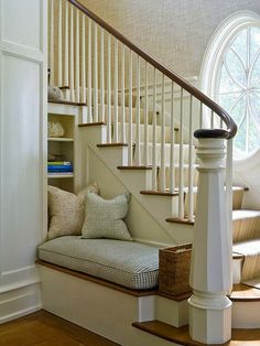 there is a white stair case with pillows on it and a window in the background