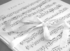 sheet music with white ribbon tied around it