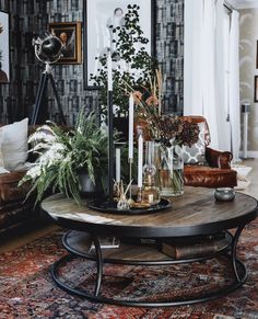 a living room filled with furniture and plants on top of a coffee table in front of a couch