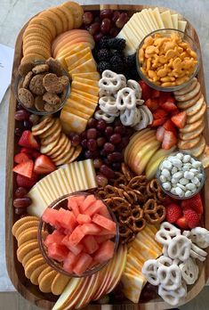 a platter filled with cheese, crackers, fruit and nuts