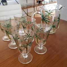 there are many glasses on the table with plants in them