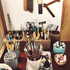 a wooden table topped with lots of art supplies