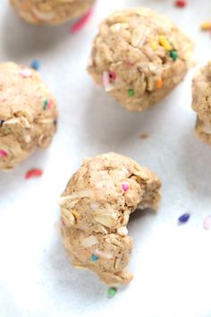 several cookies with sprinkles are on a white surface