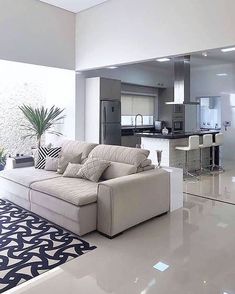 a living room filled with furniture next to a kitchen