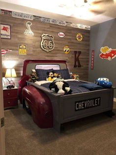 a child's bedroom with a red truck bed and toy cars on the wall