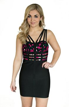 a woman posing for the camera wearing a black and pink dress with cutouts on it