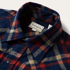 This rugged flannel shirt features a rich navy blue plaid print. Authentic Western details include a snap front, one-point curved back yoke and a three snap cuff. A spread collar with collar stays keeps the shirt looking sharp, while subtly embossed Stetson logos on the chest pocket and sleeve placket further augment the style. It’s made from a garment washed brushed twill flannel that hangs well while keeping its shape and only gets better with age. Brushed Twill Flannel One-Point Curved Back Y Fitted Plaid Flannel Shirt With Spread Collar, Plaid Shirt With Placket For Fall, Plaid Fall Shirt With Placket, Blue Shirt With Snap Buttons For Fall, Fall Plaid Shirt With Placket, Fall Blue Shirt With Snap Buttons, Relaxed Fit Collared Flannel Shirt With Buttons, Cotton Flannel Shirt With Snap Buttons For Fall, Classic Collared Flannel Shirt With Snap Buttons