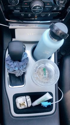 the interior of a car with various items in its place on the console and cup holder