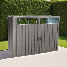 an outdoor storage shed in front of a hedge