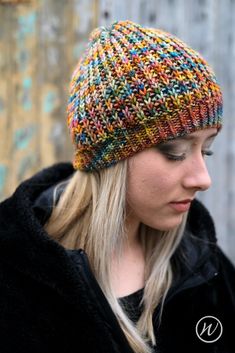 a woman wearing a multicolored knitted hat