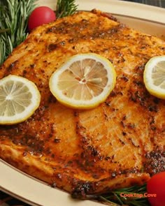 grilled chicken with lemons and rosemary garnish on a platter next to tomatoes