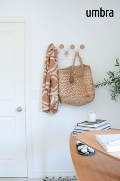 a white door with a brown bag hanging from it's side and a plant on the wall