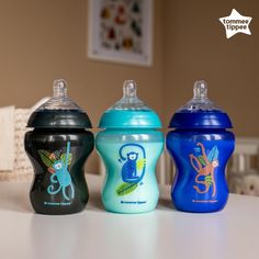 three baby bottles sitting on top of a table