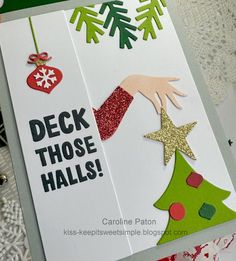 a christmas card that says deck those hills with a hand reaching for a tree ornament