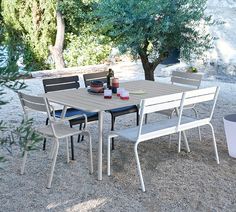 an outdoor table and chairs set up on gravel