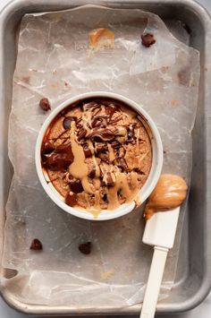 a bowl of ice cream with chocolate chunks and caramel drizzle