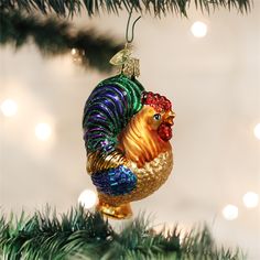 a christmas ornament with a rooster on it's head hanging from a tree