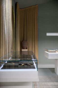 a vase sitting on top of a glass table next to a shelf with other items