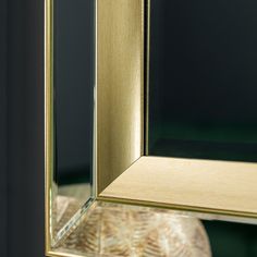 a gold framed mirror sitting on top of a table