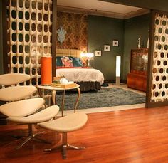 a living room filled with furniture next to a bed and a tv on top of a hard wood floor