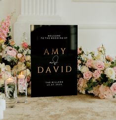 a wedding sign sitting on top of a table next to candles and flowers in vases