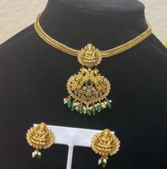 Make a statement with this stunning gold replica necklace set, featuring intricate detailing and adorned with emerald beads and Polki stones. The set includes a beautifully designed choker-style necklace with a large pendant and matching earrings, perfect for special occasions or traditional events. Gold Chandbali Bridal Necklace Jeweled, Gold Chandbali Bridal Necklace With Jeweled Details, Gold Chandbali-shaped Jeweled Bridal Necklace, Gold Plated Green Jewelry Sets For Festivals, Green Gold-plated Jewelry Sets For Festivals, Bollywood Gold Jeweled Necklaces, Gold Bollywood Necklaces With Jewels, Bollywood Style Gold Jeweled Jewelry Sets, Bollywood Style Jeweled Gold Necklace