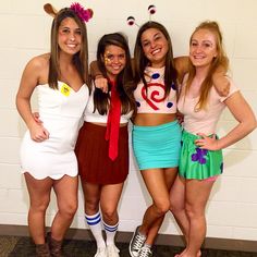 four girls dressed up in costumes posing for the camera