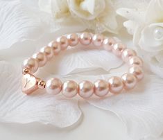 This personalized flower girl bracelet is made with blush pink color little glass pearls (8 mm) and rose gold plated hand stamped heart charm. This stretch pearl bracelet is perfect gift for your flower girls, jr bridesmaids or bridesmaids. Please visit my store to see the other wedding jewelry https://www.etsy.com/shop/asteriasbridal Personalized Rose Gold Charm Bracelet For Wedding, Elegant Personalized Pink Heart Bracelet, Adjustable Rose Gold Heart Bracelet For Wedding, Rose Gold Heart Charm Bracelet For Wedding, Rose Gold Bracelets With Pearl Charm For Wedding, Rose Gold Wedding Bracelets With Pearl Charm, Gold Flower Girl, Pink Flower Girl, Flower Girl Jewelry