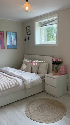 a white bed sitting in a bedroom next to a window