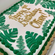 a white and green birthday cake with gold lettering