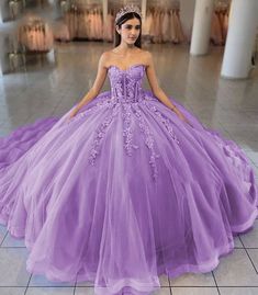 Turn your quinceanera into a fairytale with this exquisite ball-gown style dress. This dress is designed in airy tulle and available in dreamy colors like sky blue, lilac, and pink. The sweetheart neckline beautifully frames the shoulders and neckline, enhancing your look with a touch of romance. Adorned with intricate appliques and delicate 3D floral embellishments, this dress brings an enchanting garden to life. The lace-up back ensures a perfect fit, while the sleeveless design allows for gra Lilac And Pink Quinceanera Dresses, Lilac And Pink Quinceanera, Gown Style Dress, Dreamy Colors, Enchanting Garden, Quinceanera Dresses Pink, Lilac Sky, Blue Ball Gowns, Flower Girl Shoes