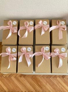 six brown boxes with pink bows on them