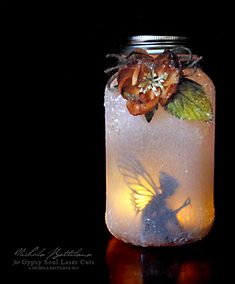 a mason jar with flowers and fairy lights in it