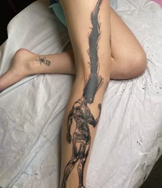 a woman laying on top of a bed covered in tattoos