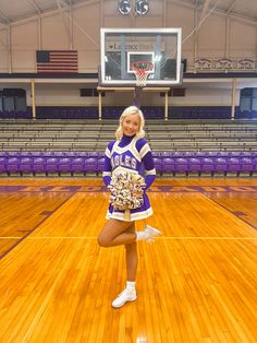 a cheerleader is posing on the basketball court