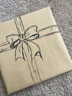 a gift wrapped in brown paper with a bow on the top is laying on carpet