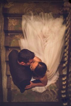 a man and woman are kissing on the stairs