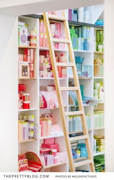 there is a ladder in the closet with many items on it and one shelf full of toiletries