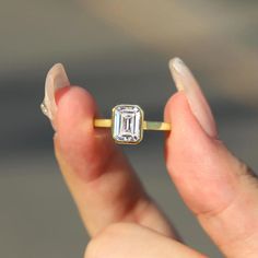 ✥The 1.0 CT Emerald Cut Diamond Solitaire Moissanite Engagement Ring features a striking 1-carat emerald-cut moissanite as its centerpiece, exuding elegance and sophistication. The elongated shape of the emerald cut accentuates the stone's clarity and brilliance, creating a stunning visual impact. Set in a sleek, minimalist band, this ring allows the beauty of the solitaire to take center stage, making it a timeless choice for an engagement ring. Its modern yet classic design ensures that it will be cherished for a lifetime, symbolizing love and commitment in a truly exquisite manner. ✦ Main Stone Details✧ Shape: Emerald Cut Moissanite✧ Weight: 1.0 CT(App. 5.0*7.0 mm) 2.0 CT(App. 7.0*8.0mm) 3.0 CT(App. 7.0*9.0 mm)✧ Color: DEF(Colorless)✧ Clarity: VVS ✦ Ring Details✧ Band Width: 1.8mm (± 0. Moissanite Jewelry With Single Diamond For Proposal, Proposal Moissanite Jewelry With Single Diamond, Moissanite Emerald Cut Diamond Ring For Proposal, Baguette Cut Moissanite Emerald Ring Gift, Moissanite Emerald Ring Baguette Cut Gift, Gift Moissanite Emerald Ring Baguette Cut, Gift Emerald Moissanite Ring Baguette Cut, Moissanite Emerald Cut Ring For Gift, Emerald Cut Diamond Emerald Ring In Rose Gold