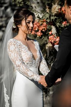 a bride and groom holding hands during their wedding ceremony