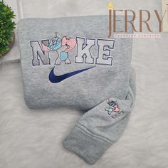 a gray sweatshirt and sweatpants with an elephant on the front is laying next to a potted plant