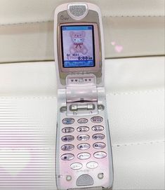 an old cell phone with a teddy bear on the screen