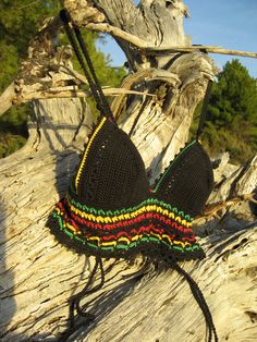 two black crocheted bras with multicolored trim sitting on driftwood