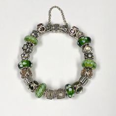 Pandora Green/Silver Completed Charm Bracelet In Excellent, Pre-Owned Condition All Of The Beads Are Retired/Discontinued. Circa Mid 2000s (2007-2008). Bracelet Was Probably Worn Less Than 5 Times Hence The Clean Condition. Retail Was Well Over $1,000 With All The Beads To Build. - 20 Beads Total - 2 Sterling Silver Clips - 1 Snake Chain Moments Bracelet - 1 Safety Chain 8.25” Overall Length With Beads Attached 2.5” Length For Safety Chain Elegant Green Bracelets With Silver Beads, Green Sterling Silver Bracelets With Silver Beads, Green Sterling Silver Bracelet With Silver Beads, Green Silver Beads Bracelet, Elegant Green Bracelets With Sterling Silver Clasp, Green Sterling Silver Jubilee Bracelet, Green Sterling Silver Bracelets With Silver Clasp, Green Pandora Bracelet, Pandora Green