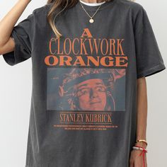 A Clockwork Orange movie vintage faded t-shirt for men and women. Stanley Kubrick's A Clockwork Orange alternate movie poster shirt. Our A Clockwork Orange unisex graphic tee shirt is printed on your choice of a standard t-shirt or a premium heavyweight faded graphic tee. Premium t-shirts (Comfort Colors 1717 Shirt) - Pepper Standard t-shirts - Black - White - Sand - Charcoal - Sport Grey Our retro movie shirt features a striking graphic inspired by the iconic eyeball scene from "A Clockwork Ora Stanley Kubrick Movies, Movie Lover Gift, A Clockwork Orange, Orange T Shirt, Movie Tees, Clockwork Orange, Stanley Kubrick, Orange T Shirts, Movie Shirts