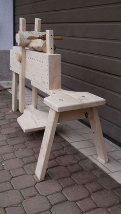 a wooden bench sitting on top of a brick floor next to a garage door with a hammer in it