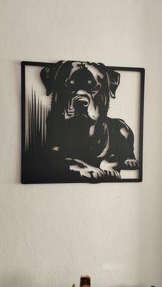 a black and white photo of a dog hanging on the wall above a shelf with bottles