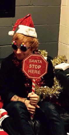 a man in a santa hat holding a stop sign